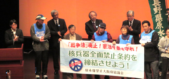 全体集会で壇上で決意表明する大阪代表団の青年たち